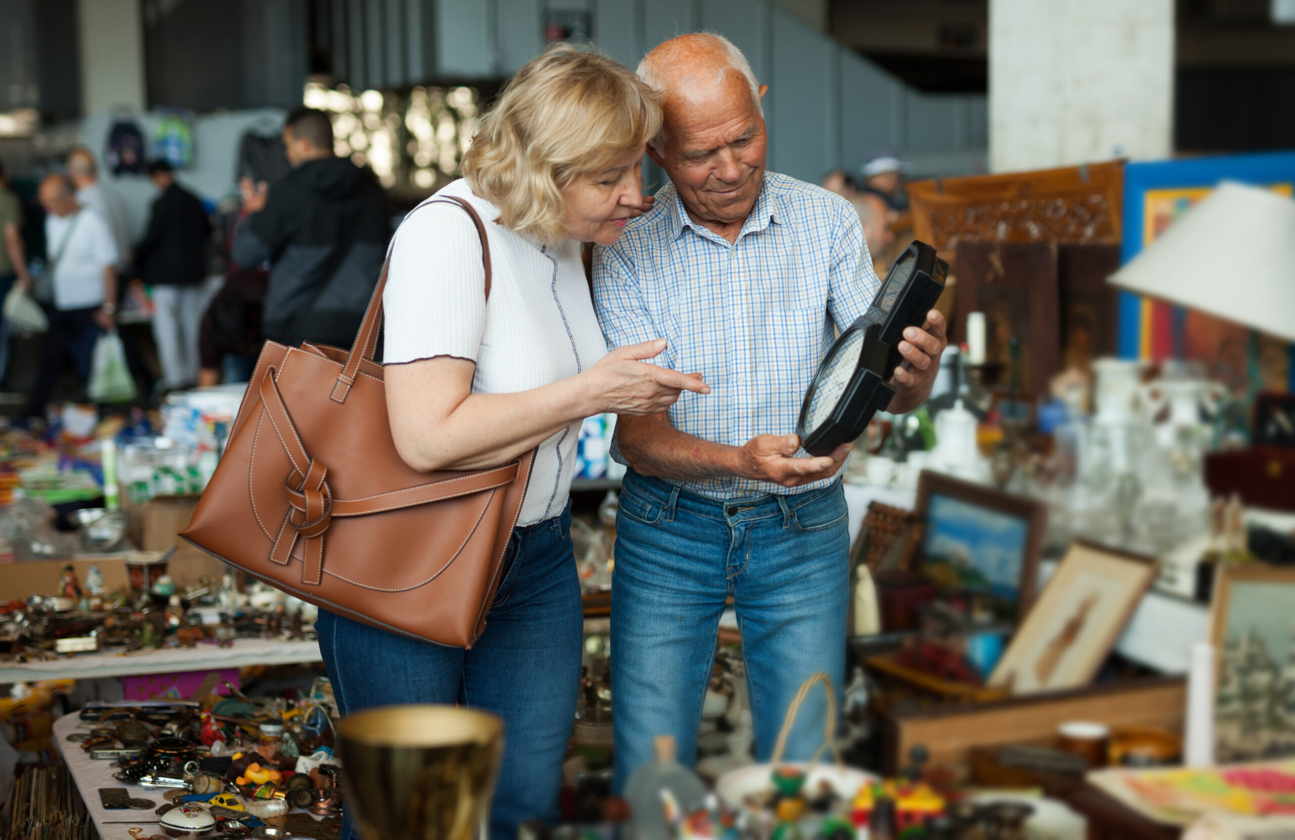 Elderly couple in flea market chooses antique items